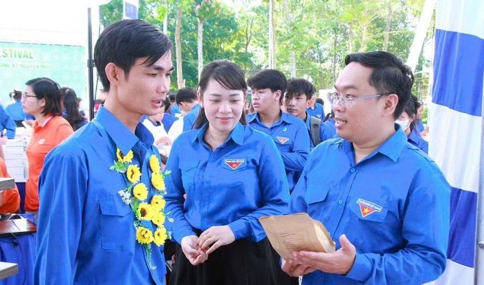 Anh Nguyễn Minh Kiên (bìa phải) trao đổi, động viên các đoàn viên thanh niên trong khởi nghiệp, phát triển thương hiệu sản phẩm địa phương.
