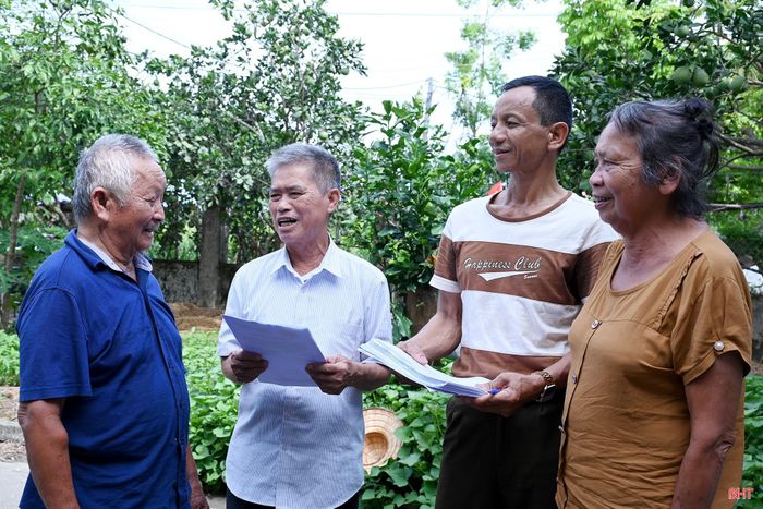 Cán bộ thôn ở xã Đức Thịnh trao đổi với người dân về việc lấy ý kiến sắp xếp thôn.