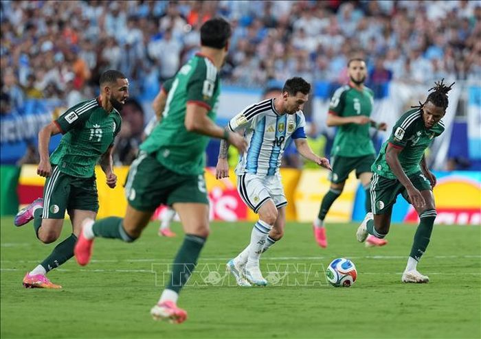 Pha đi bóng của tiền đạo Argentina Lionel Messi qua các cầu thủ Algeria. Ảnh: THX/TTXVN