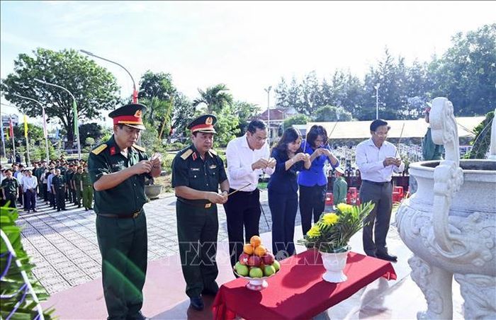 Thắp nhang tri ân tại Nghĩa trang liệt sĩ xã Trần Văn Thời trước khi khai quật lấy mẫu ADN ở các mộ chưa xác định danh tính. Ảnh: TTXVN phát