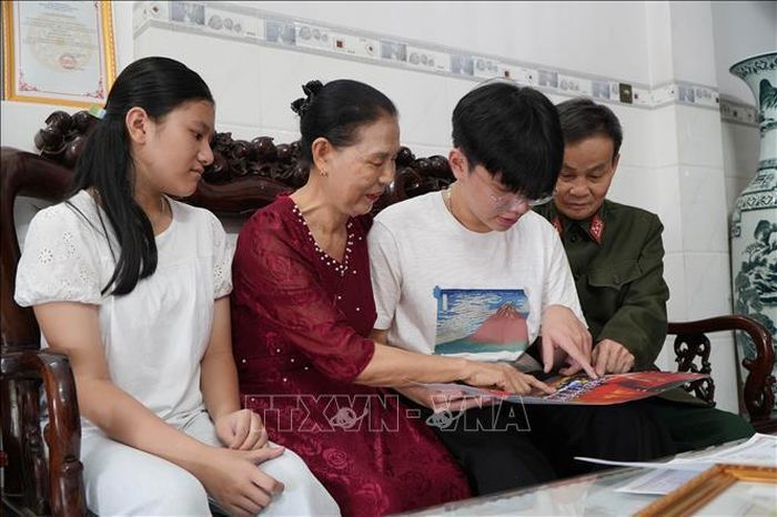 Em Lê Gia Vinh (học sinh lớp 9/5, Trường trung học cơ sở Hùng Vương, phường Trảng Bom, thành phố Đồng Nai) cùng gia đình xem lại những khoảnh khắc khi em được bầu chọn làm Chủ tịch Quốc hội trong phiên họp giả định “Quốc hội trẻ em” lần thứ II.