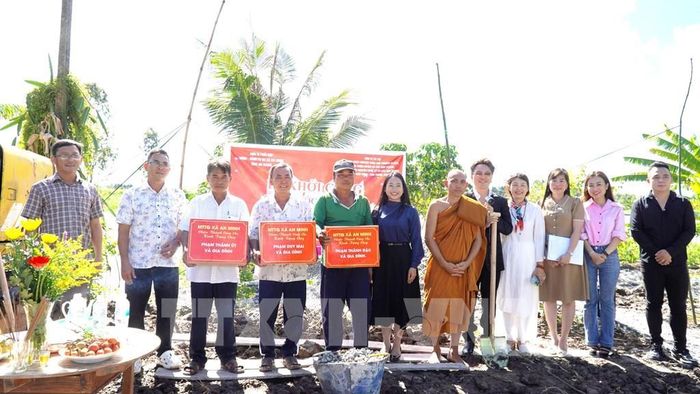 Ban tổ chức tặng quà cho những hộ dân hiến đất 2 bên dốc cầu. Ảnh: Văn Sĩ - TTXVN