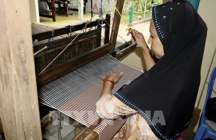 Những sợi chỉ nhiều màu sắc được người thợ khéo léo đan kết, tạo nên các hoa văn đặc trưng của văn hóa Chăm. Ảnh: Thanh Sang - TTXVN