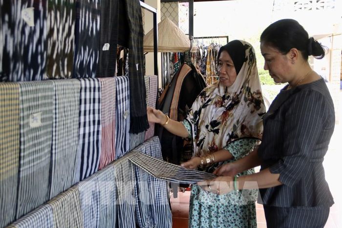 Du khách tham quan, tìm hiểu quy trình dệt thổ cẩm truyền thống tại làng Chăm Châu Phong, An Giang. Ảnh: Thanh Sang - TTXVN