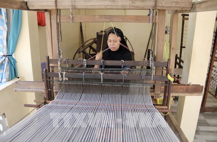Nghệ nhân Chăm (xã Châu Phong, tỉnh An Giang) tỉ mỉ thực hiện các công đoạn dệt thổ cẩm trên khung dệt thủ công truyền thống. Ảnh: Thanh Sang - TTXVN