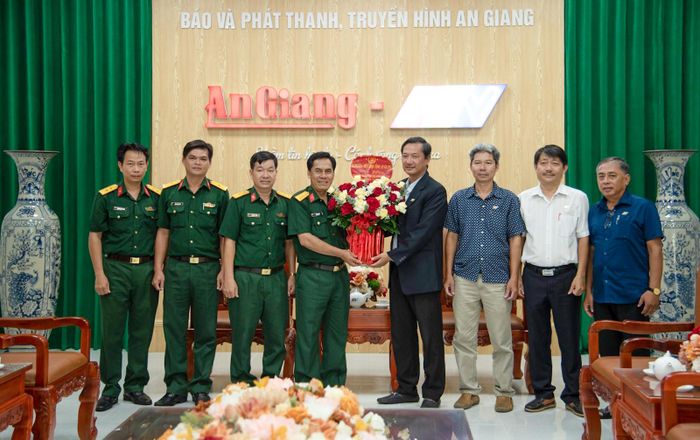 Đại tá Chau Chắc (thứ tư, từ trái qua), Phó Chính ủy Bộ Chỉ huy Quân sự tỉnh An Giang tặng hoa chúc mừng tập thể Báo và Phát thanh - Truyền hình An Giang.