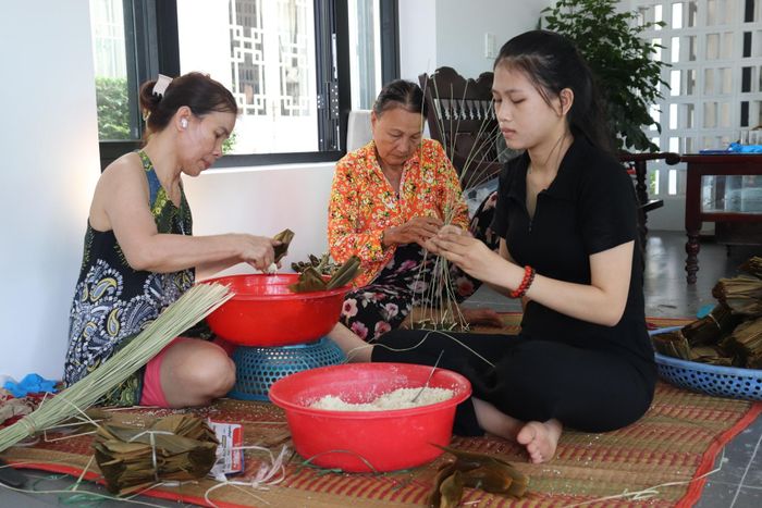Người dân tất bật gói bánh ú tro để chuẩn bị giao cho khách dịp Tết Đoan Ngọ. Ảnh: KHÁNH NGÂN