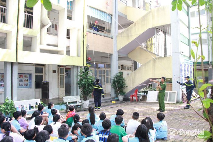 Các em thiếu nhi được hướng dẫn và trải nghiệm kỹ năng thoát nạn bằng dây hạ chậm. Ảnh: Nga Sơn