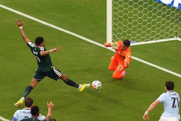Trung vệ Arab Saudi Al Amri (áo xanh lá) đá bồi làm bó tay thủ môn Uruguay Fernando Muslera ở trận ra quân bảng H ngày 15-6. Ảnh: AP