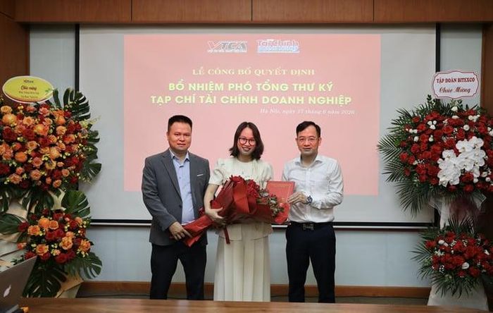  TS. Hà Khắc Minh, Tổng biên tập và ông Từ Đào Nguyên, Phó tổng biên tập trao quyết định bổ nhiệm và tặng hoa cho Phó tổng thư ký tòa soạn Hoàng Thị Nhung. 