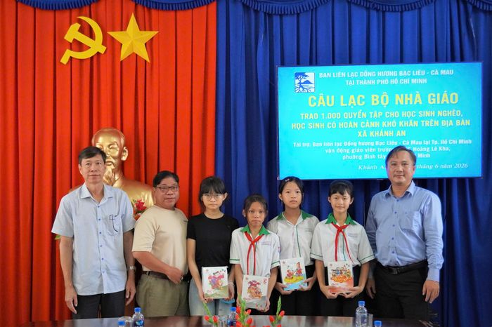 Nhà giáo Trần Văn Thuận (thứ hai từ trái sang) cùng đại diện địa phương trao tận tay những quyển tập mới cho học sinh có hoàn cảnh khó khăn tại xã Khánh An, tỉnh Cà Mau.