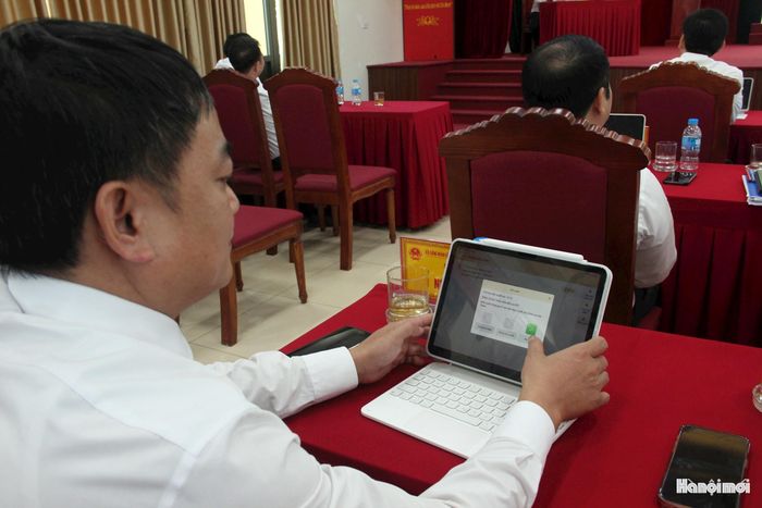 Các đại biểu HĐND xã Vĩnh Thanh thực hiện biểu quyết trên nền tảng số. Ảnh: TH