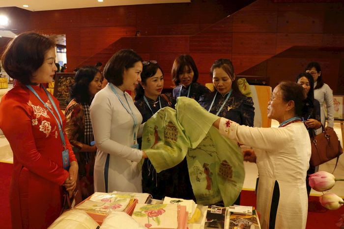 Các đại biểu tham quan gian trưng bày các sản phẩm lụa từ tơ sen của nghệ nhân Phan Thị Thuận. Ảnh: Hoàng Lan