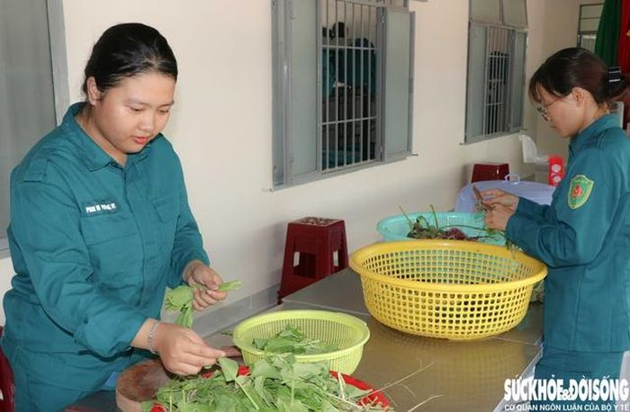 Sau giờ học tập, huấn luyện, khi nhiều người tranh thủ nghỉ ngơi, chị Phan Mai Phương Ny (trái) và chị Đặng Thị Sanh (phải) lại tất bật với công việc hậu cần. Ảnh: Duy Ngọc.