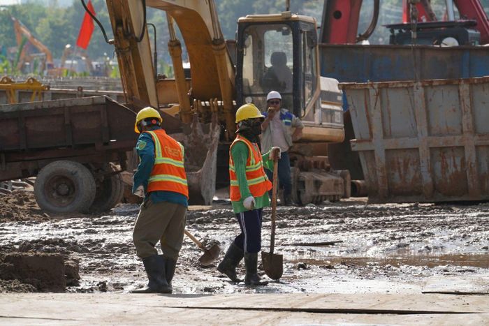 Công nhân tất bật thi công, máy móc hoạt động liên tục tại công trường dự án.