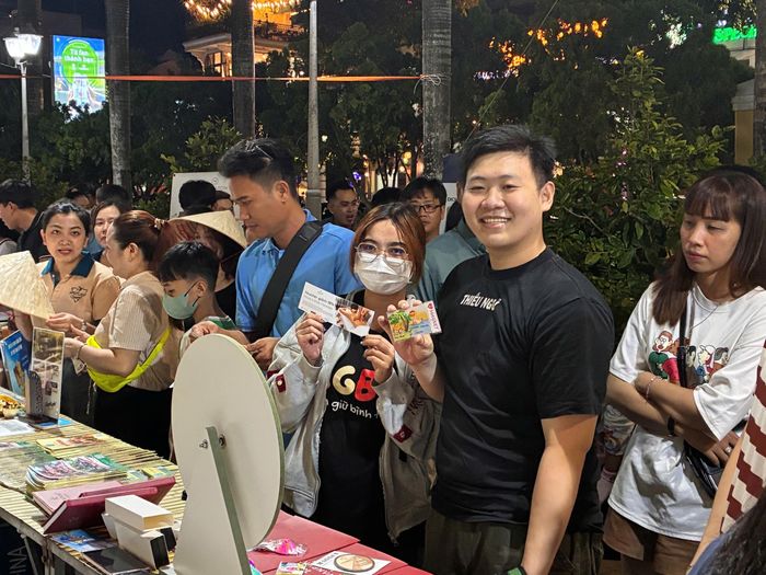  Du khách phấn khởi với voucher dịch vụ được tặng khi tham quan gian hàng tại Tuần lễ Văn hóa - Du lịch. Ảnh: NHẪN NAM 