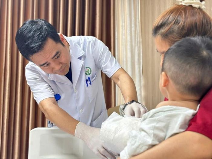 TTƯT.TS.BS. Vũ Trung Trực - Phó trưởng Khoa Phẫu thuật Hàm mặt - Tạo hình và Thẩm mỹ thăm khám vết thương cho người bệnh sau 6 ngày mổ