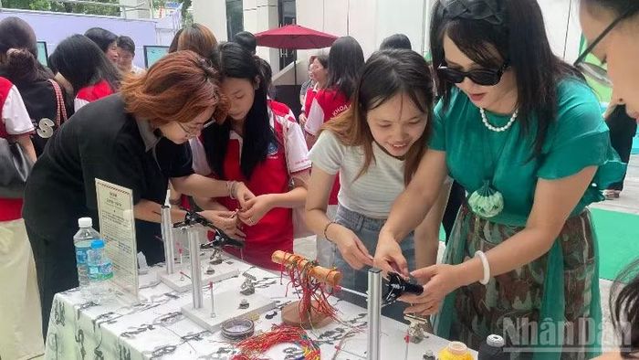 Khách tham dự trải nghiệm đan dây ngũ sắc.