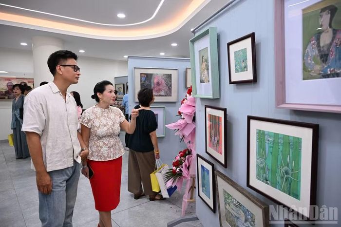 Họa sĩ Kim Duẩn (bên trái) tại Triển lãm.
