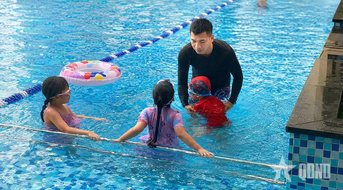 Các em nhỏ học bơi dưới sự hướng dẫn của huấn luyện viên.