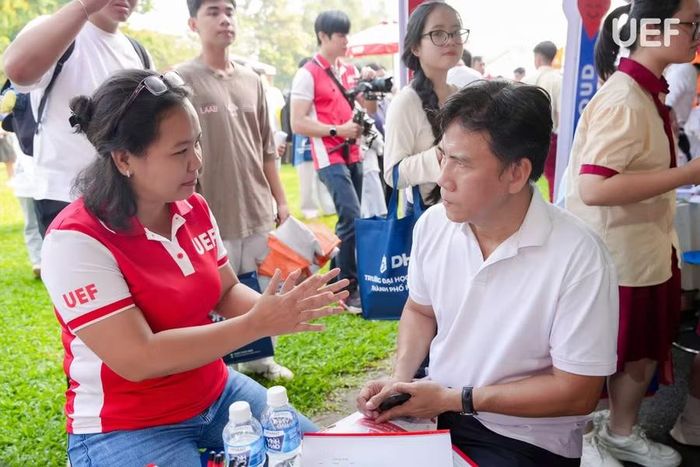 ThS. Trương Thị Ngọc Bích - Giám đốc Trung tâm Thông tin - Truyền thông, Trường Đại học Kinh tế - Tài chính TPHCM (trái) trao đổi với phụ huynh về thông tin tuyển sinh. Ảnh: UEF.