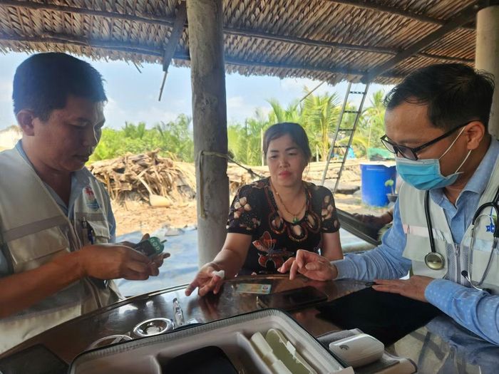 BS-CK2 Nguyễn Văn Gấm, Giám đốc Trạm Y tế xã Hiệp Phước (bên trái), đến tận nhà thăm khám, kiểm tra đường huyết cho người dân Ảnh: Vân Sơn