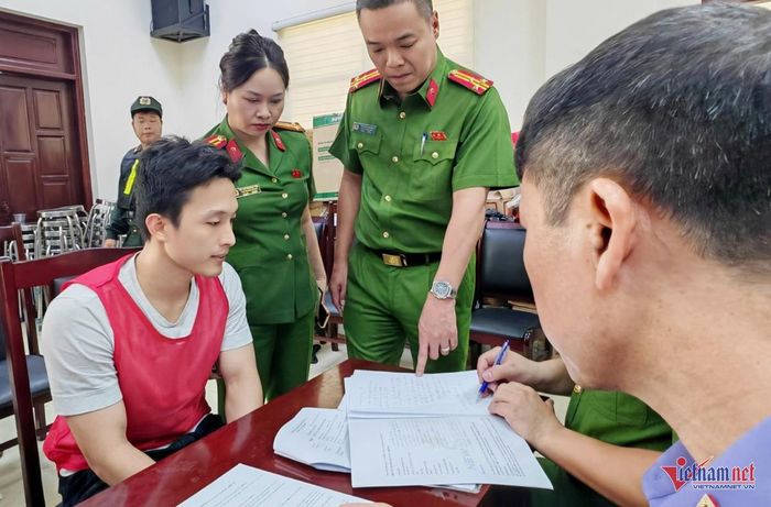Đối tượng Hoàng Nhất Long (áo khoác đỏ), Giám đốc Công ty SunLand Travel, làm việc với cơ quan công an. Ảnh: T.D