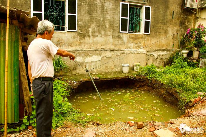 Ông Dương Văn Khái đứng cạnh hố sụt.