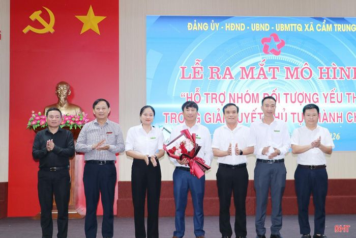 Phó Trưởng ban Tuyên giáo và Dân vận Tỉnh ủy Nguyễn Trọng Tứ cùng lãnh đạo xã Cẩm Trung tặng hoa chúc mừng các thành viên tổ hỗ trợ nhóm đối tượng yếu thế trong giải quyết thủ tục hành chính.