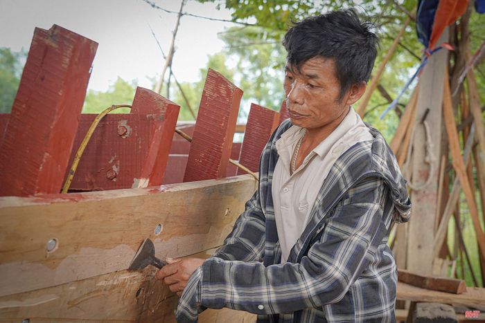 Ông Nguyễn Văn Thức cùng thợ thuyền tại xưởng của ông Nguyễn Công Hoành hoàn thiện phần thô cho chiếc thuyền của gia đình.