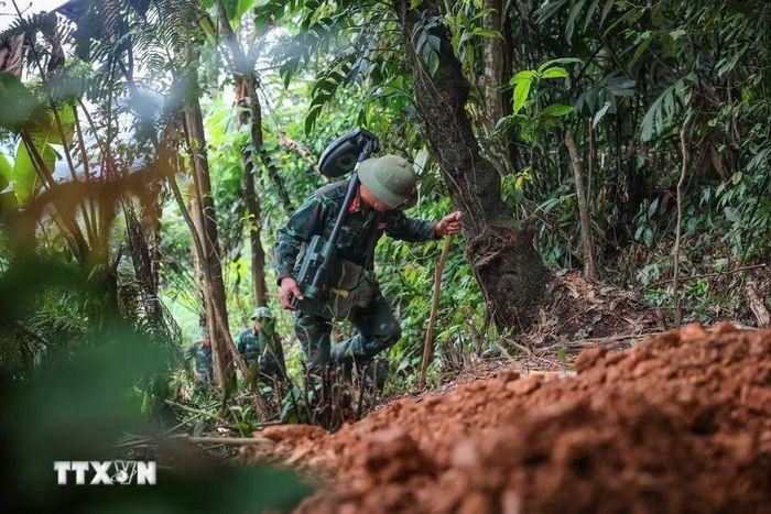 Địa hình đồi núi hiểm trở khiến hành trình của các thành viên Đội đến điểm tìm kiếm gặp nhiều gian nan, vất vả. (Ảnh: Hoàng Hiếu/TTXVN)