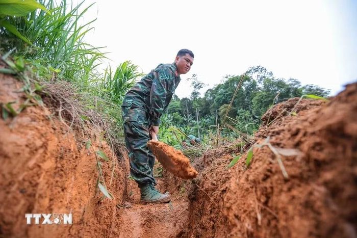 Các thành viên Đội tiến hành tìm kiếm tại khu vực nghi có hài cốt liệt sỹ tại xã Minh Tân. (Ảnh: Hoàng Hiếu/TTXVN)