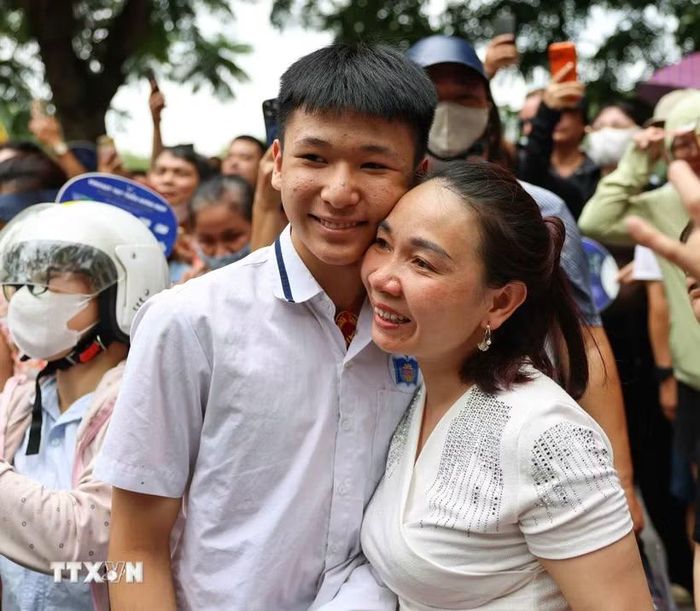 Phụ huynh vui mừng đón thí sinh sau khi hoàn thành môn thi đầu tiên tại điểm thi Trường Trung học phổ thông Trần Nhân Tông. (Ảnh: Thanh Tùng/ TTXVN)