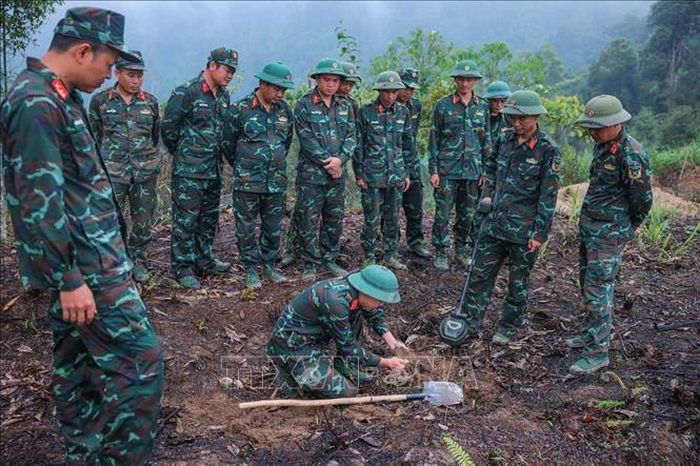 Các thành viên Đội tìm kiếm, quy tập hài cốt liệt sĩ sử dụng máy dò mìn để đảm bảo khu vực tìm kiếm "sạch" trước khi tiến hành tìm kiếm.