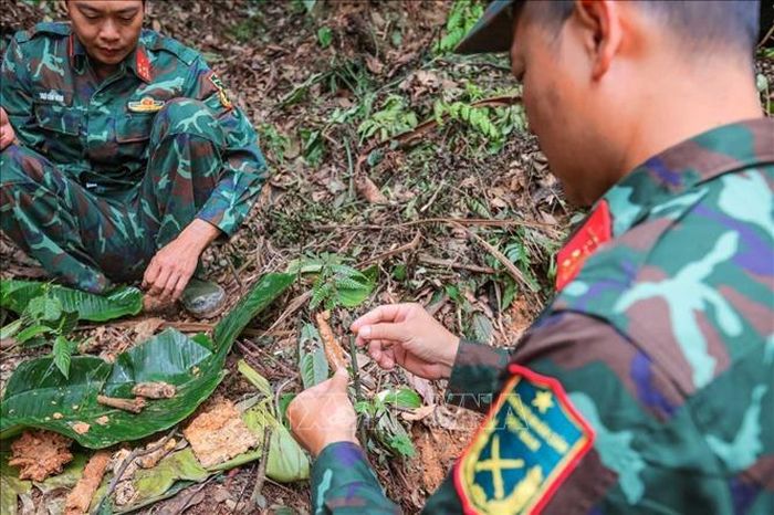 Trung tá Hoàng Vũ Dũng - Đội phó đội tìm kiếm, quy tập hài cốt liệt sĩ Tuyên Quang xem xét cẩn thận mảnh xương nghi là của người tại khu vực nghi có hài cốt liệt sĩ thuộc chiến trường xưa - xã Minh Tân.