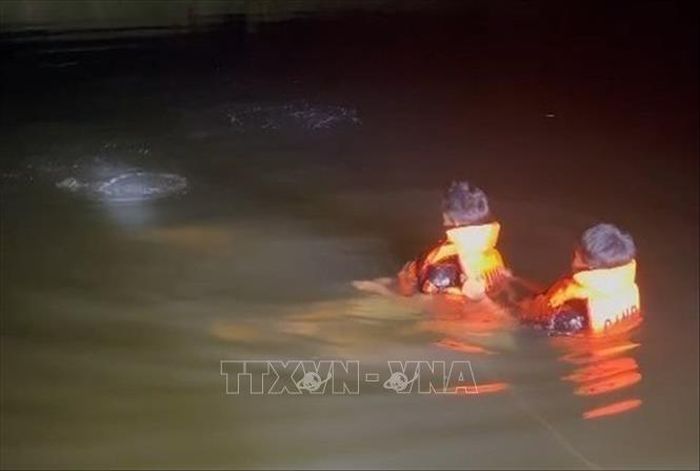 Lực lượng chức năng tìm kiếm nạn nhân bị tai nạn đuối nước trong đêm. Ảnh: TTXVN phát