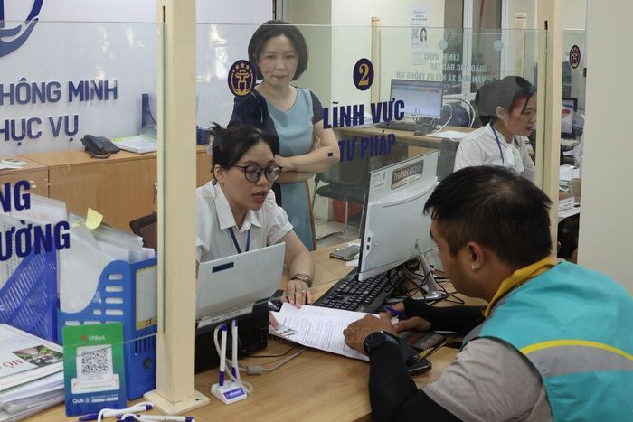 Cán bộ, công chức tận tình giải đáp thắc mắc, hỗ trợ giải quyết hồ sơ cho nhân dân tại Điểm phục vụ Hành chính công Hai Bà Trưng. Ảnh: Vũ Quang/TTXVN