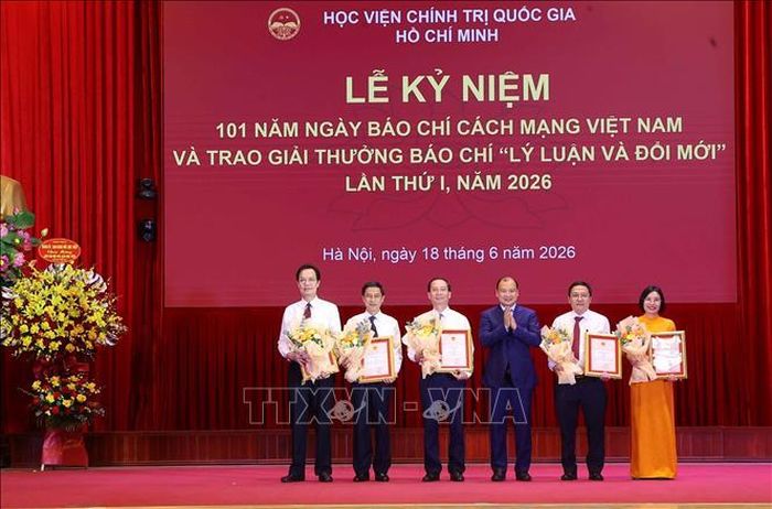 PGS.TS Lê Hải Bình, Phó Giám đốc Thường trực Học viện Chính trị quốc gia Hồ Chí Minh trao giải Nhì cho các tác giả đoạt giải. Ảnh: Văn Điệp/TTXVN