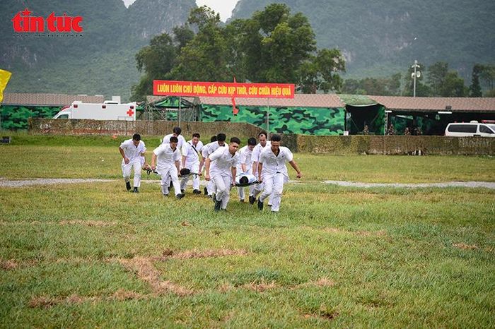 Các y, bác sĩ nhanh chóng cơ động cáng cứu thương từ trực thăng.