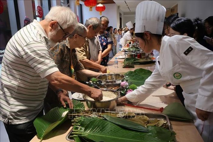 Đại biểu trải nghiệm gói bánh ú. Ảnh: Hạnh Quyên/TTXVN