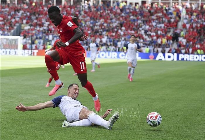 Tiền đạo Tani Oluwaseyi (phía trên) của Canada nỗ lực đi bóng qua tuyển thủ Bosnia-Herzegovina trong trận ra quân ở bảng B World Cup 2026 trên sân vận động Toronto (Canada). Ảnh: TTXVN phát. Ảnh minh họa: THX/TTXVN