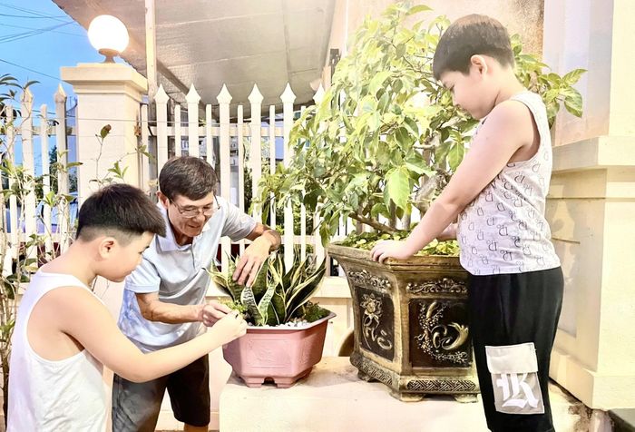 Ông Nguyễn Văn Thắng cùng các cháu chăm sóc cây xanh.