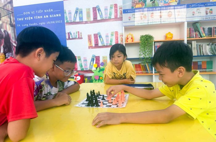 Các bạn nhỏ lập nhóm chơi cờ vua khi đến Thư viện tỉnh những ngày hè. Ảnh: PHƯƠNG LAN