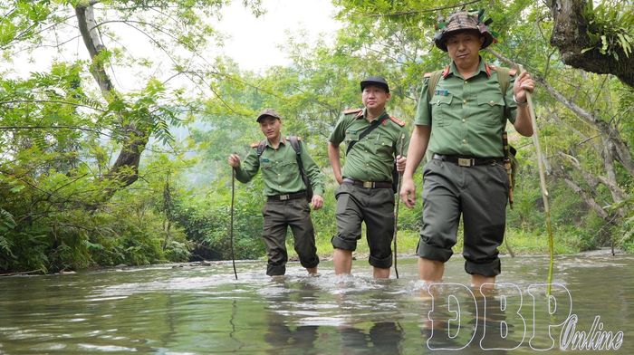 Thiếu tá Giàng A Chù, cán bộ Phòng An ninh nội địa Công an tỉnh cùng động nghiệp vượt qua những con suối đến với nhân dân Nậm Kè để phổ biến pháp luật.