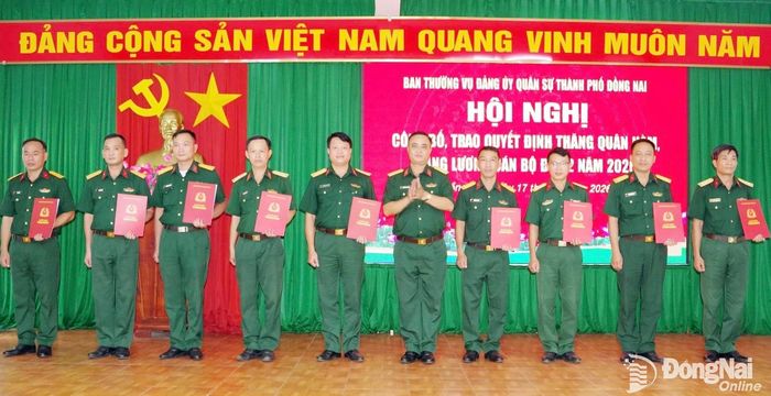 Đại tá Nguyễn Danh Trang, Chủ nhiệm Chính trị Bộ Chỉ huy Quân sự thành phố trao quyết định cho các cán bộ. Ảnh: ĐVCC