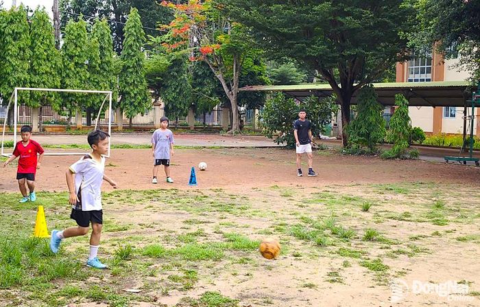 Anh Tạ Văn Chiến, Huấn luyện viên Đội U11 phường Bình Lộc hướng dẫn các cầu thủ chạy vị trí trên sân bóng. Ảnh: CTV