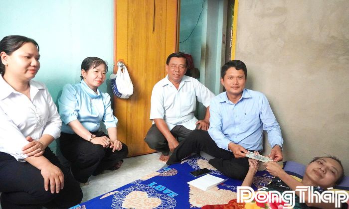 Đồng chí Huỳnh Thanh Triều, Chủ tịch Ủy ban Mặt trận Tổ quốc Việt Nam xã Long Bình trao quà cho em Trương Hoàng Dương.