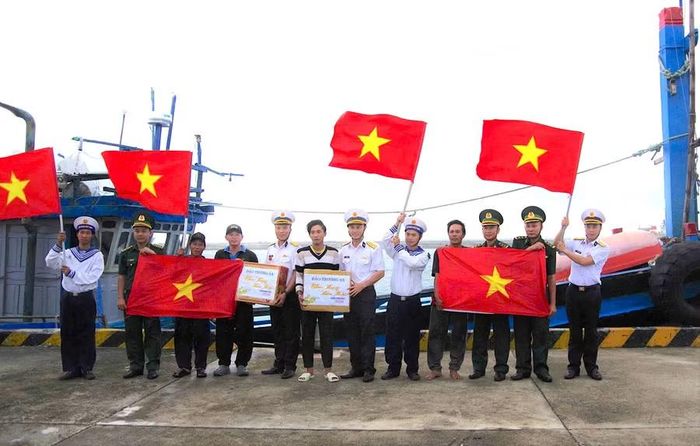  Bà con ngư dân nhận hỗ trợ của cán bộ, chiến sĩ đảo Trường Sa khi khai thác thủy sản. Ảnh: Mỹ Hà 