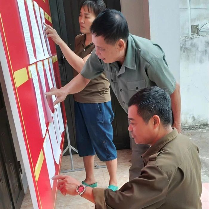 Người dân theo dõi thông tin về sắp xếp tổ dân phố.