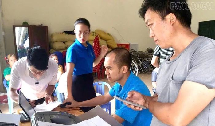 Cán bộ Bảo hiểm xã hội cơ sở Bát Xát hướng dẫn người dân hoàn thiện hồ sơ tham gia bảo hiểm xã hội bắt buộc.